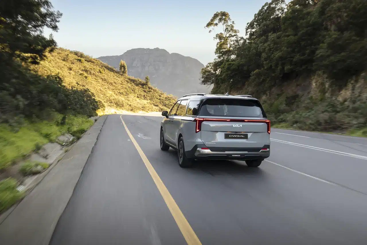 Kia Carnival driving along a mountain road