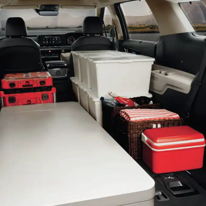Kia Carnival luggage mode with folded seating and travel cases in the cabin