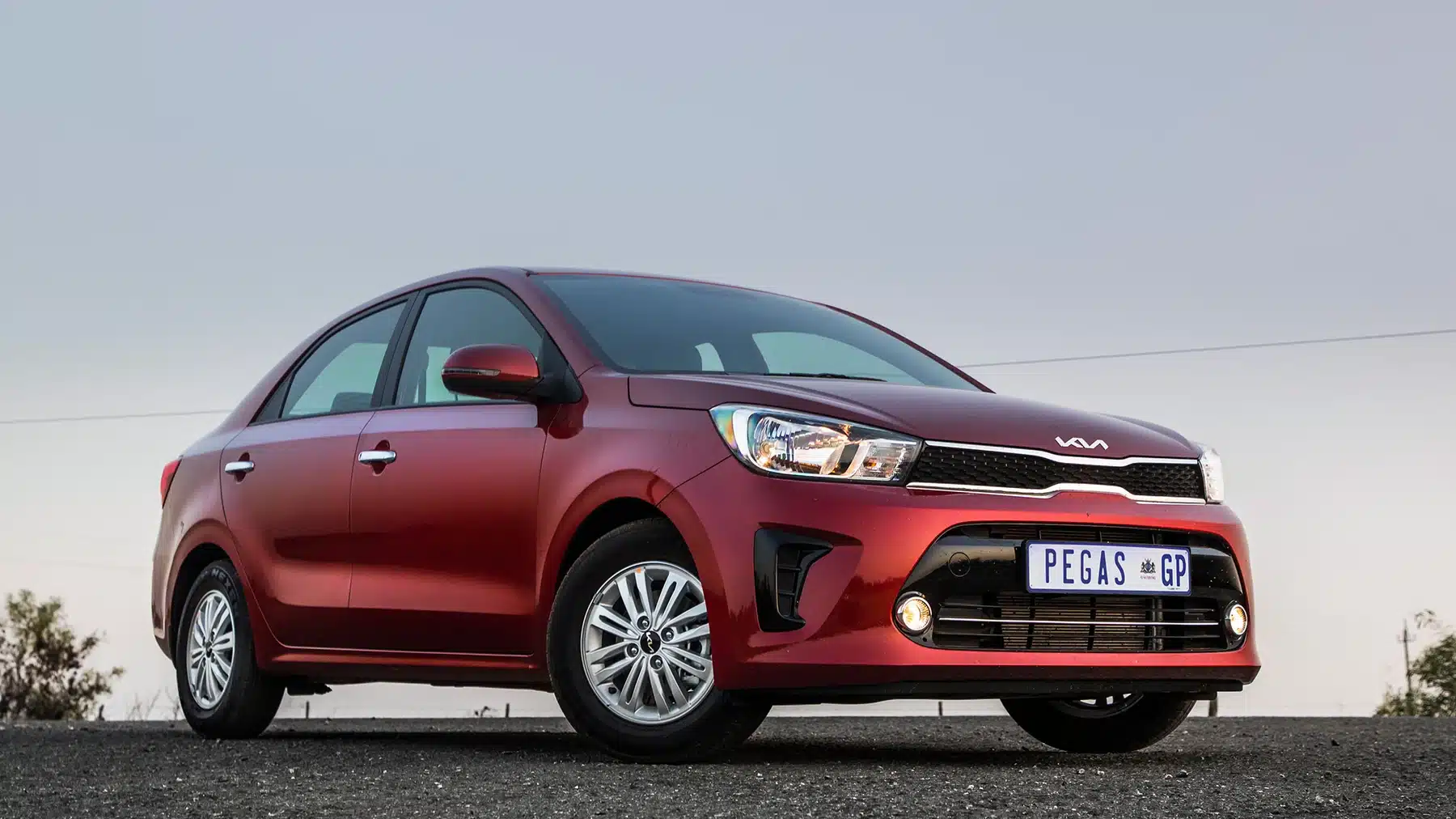 Red Kia Pegas front three-quarter exterior view