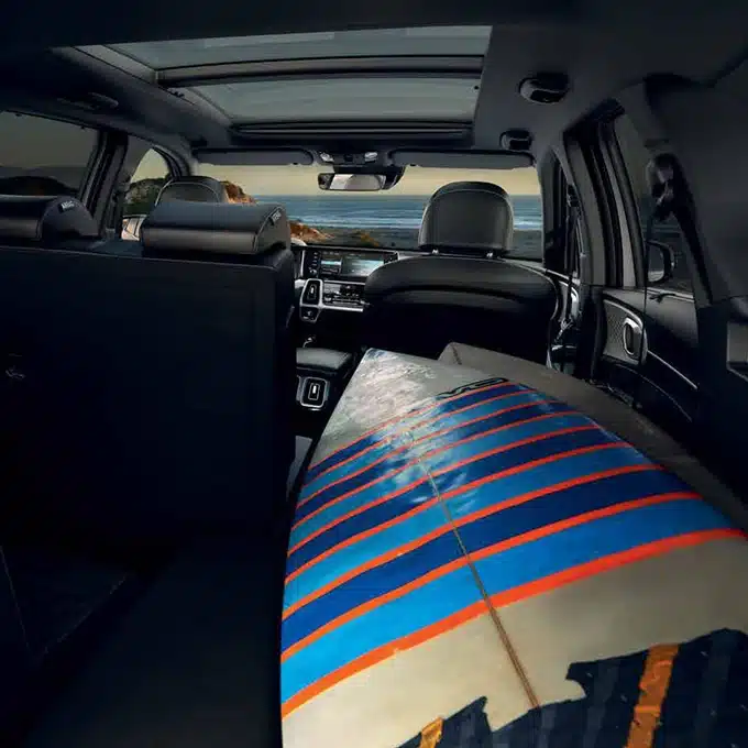 Kia Sorento cabin with a rear seat folded to carry a surfboard